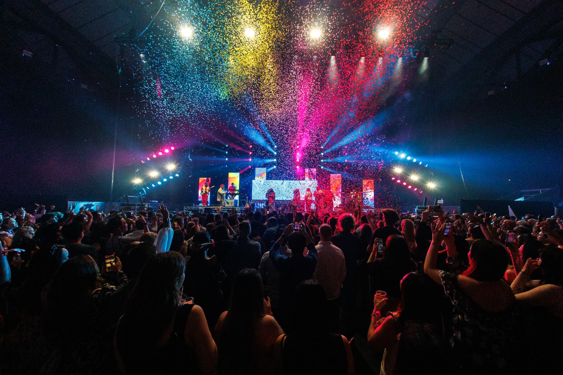 Crowd watching a confetti-filled arena concert at a Chemist Warehouse event