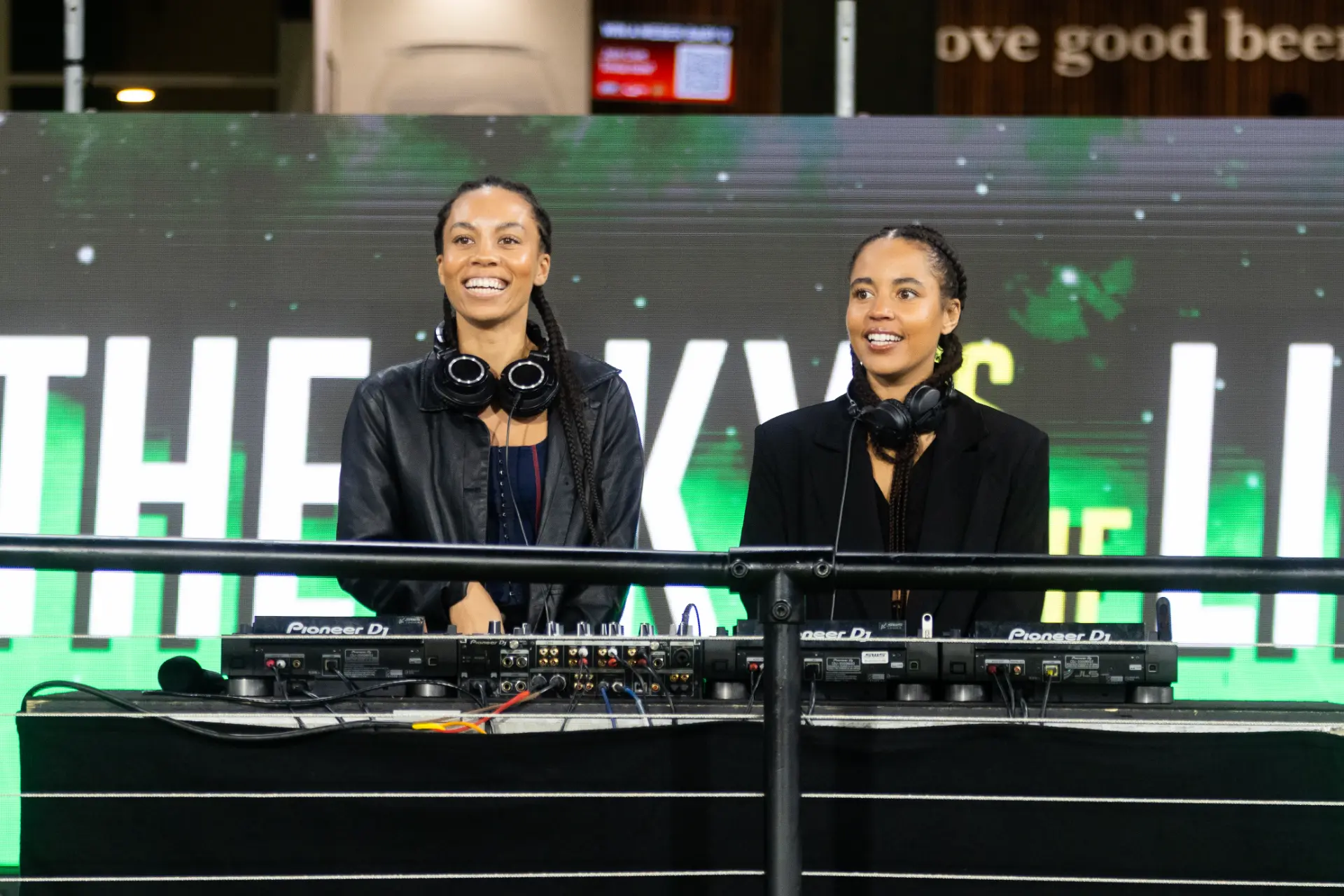 Two DJs smiling behind Pioneer DJ decks at a WBBL Melbourne event