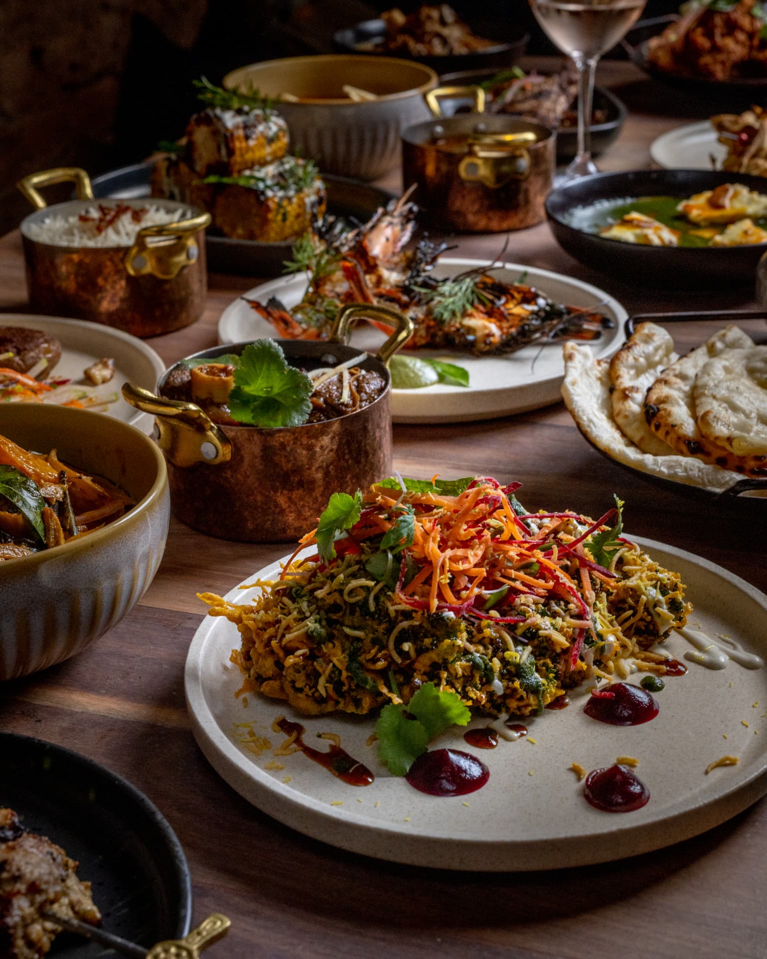 Curry, naan and shared plates on a restaurant table