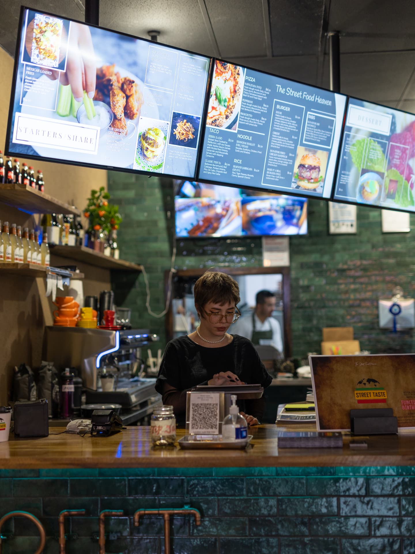 Counter service beneath menu boards at a street food venue
