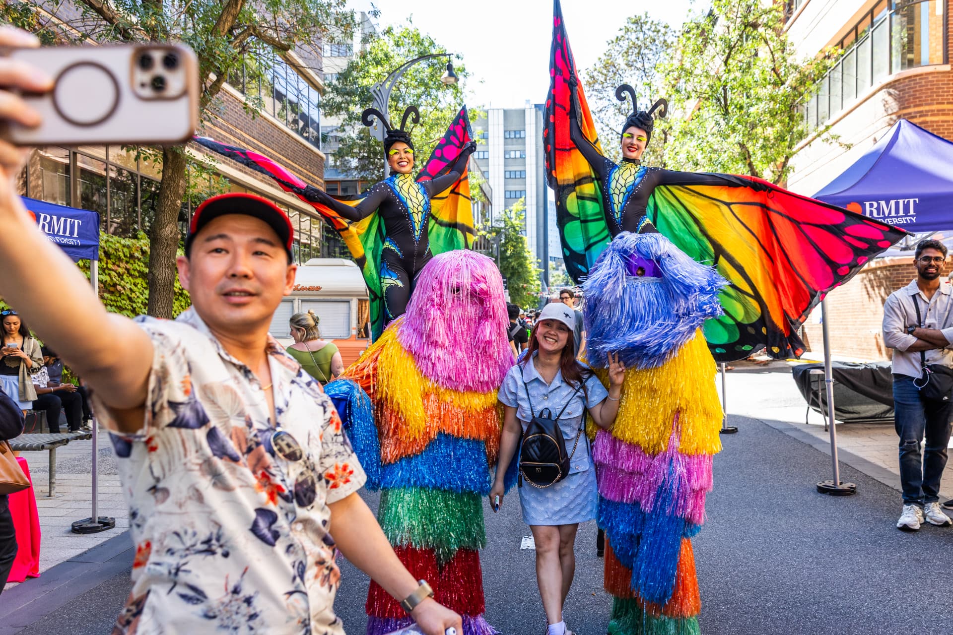 Colourful butterfly stilt walkers at an RMIT University street festival